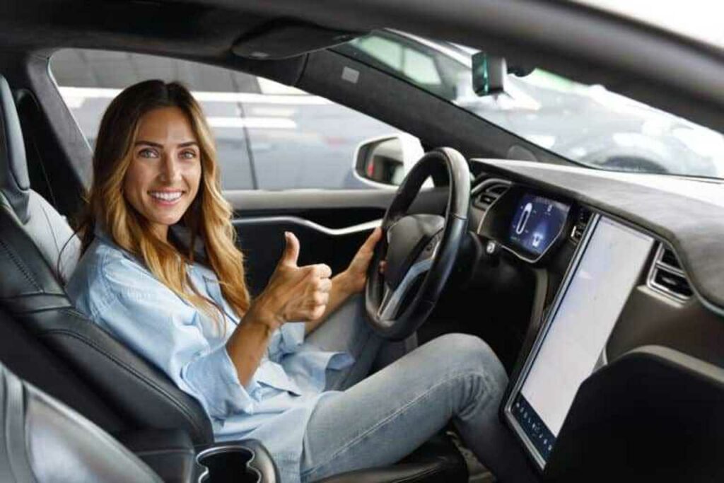 woman sitting in the car showing a thumbs up Harvey Insurance