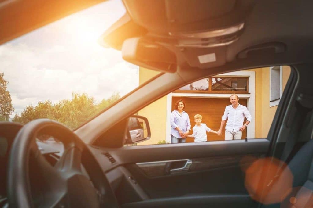 a photo of a family looking into their car